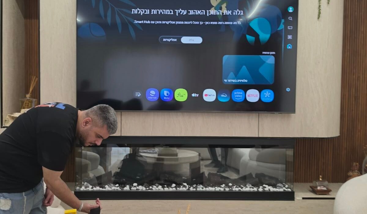 טלוויזיה 98 אינץ' מותקנת על זרוע מפרקית עם קיר חיפוי עץ בסלון בנשר