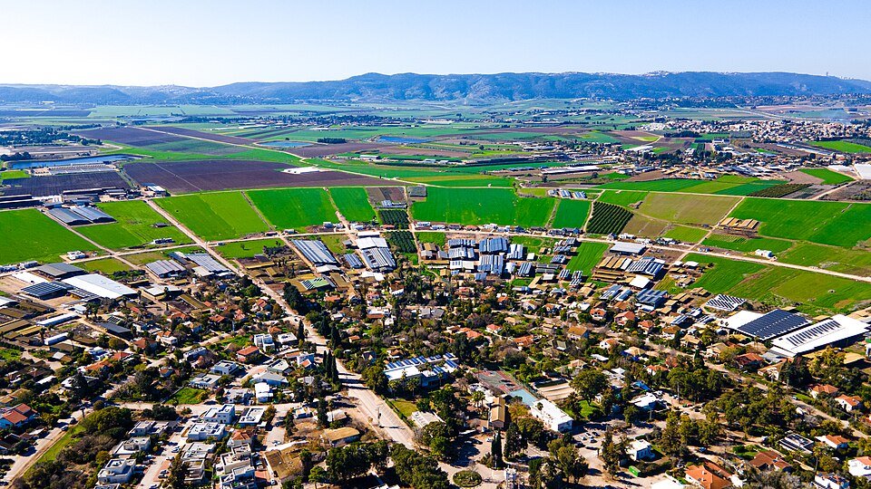 נהלל צילום אווירי של בתים ושדות ירוקים במושב בצפון