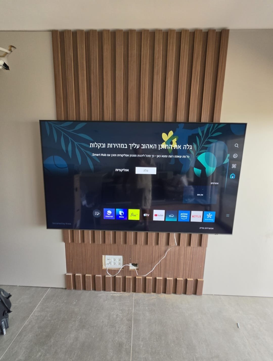 Read more about the article טלוויזיה 75 אינץ' מותקנת על זרוע מפרקית עם קיר עם קיר חיפוי פלסטיק בסלון בנשר