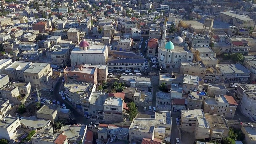 שפרעם מבט אווירי על העיר עם בתי מגורים ונוף גלילי