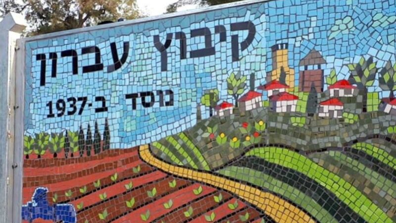שלט הכניסה לקיבוץ עברון, ניצב על רקע נוף פסטורלי המאפיין את הכניסה לישוב.