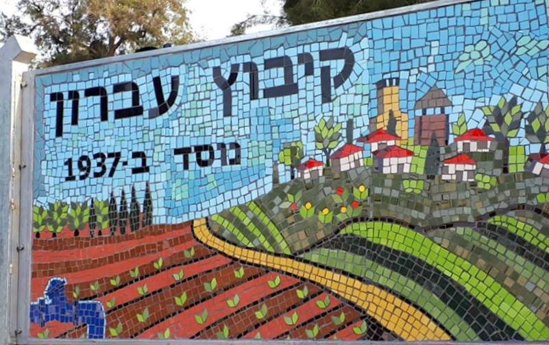 שלט הכניסה לקיבוץ עברון, ניצב על רקע נוף פסטורלי המאפיין את הכניסה לישוב.