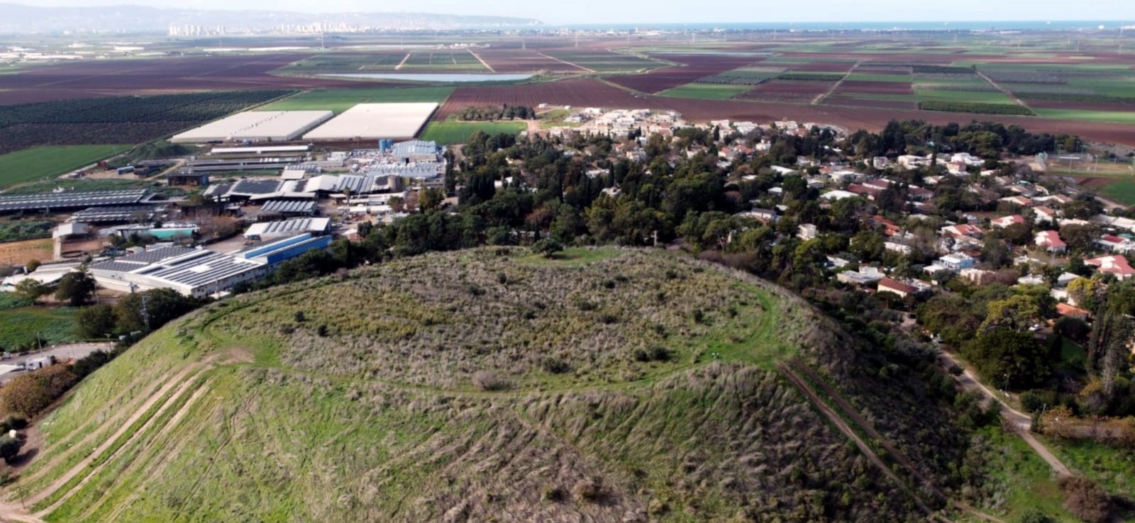 תמונת נוף מרהיבה המשקיפה מהר סמוך על היישוב יסעור, המציגה את הבתים משתלבים בטבע עם מדרונות ירוקים ברקע.