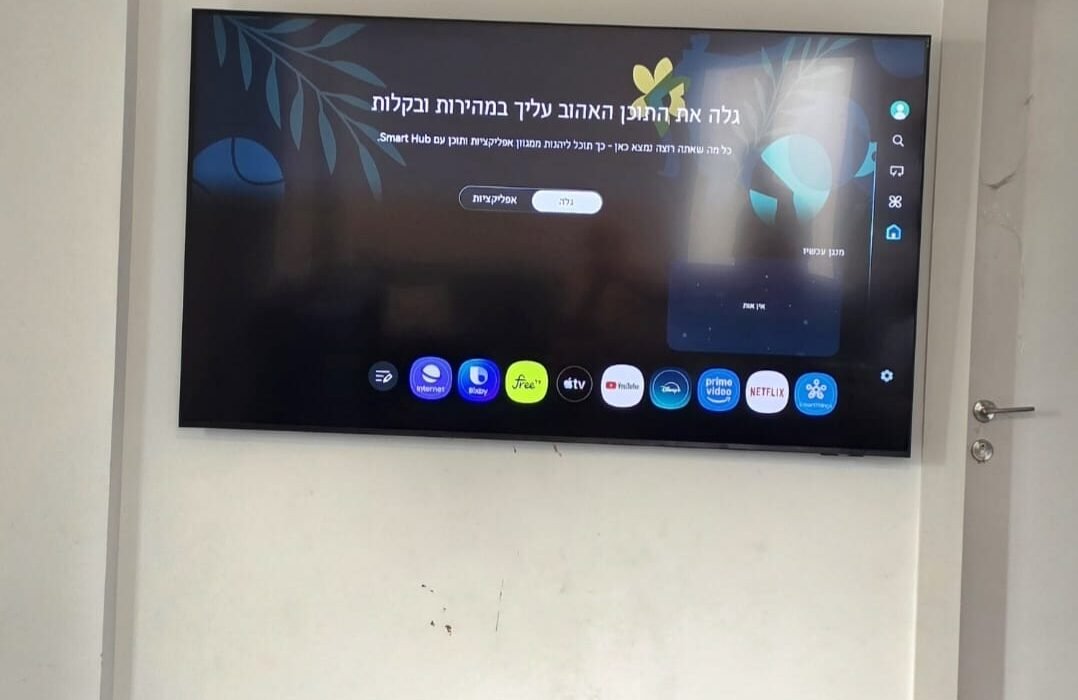 טלוויזיה 75 אינץ' מותקנת על מתקן צמוד קיר בקיר בטון בנשר