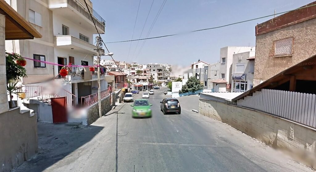 מראה רחוב בטמרה המציג את הבנייה המקומית, שילוב של בתים ודירות באווירה אורבנית פעילה.