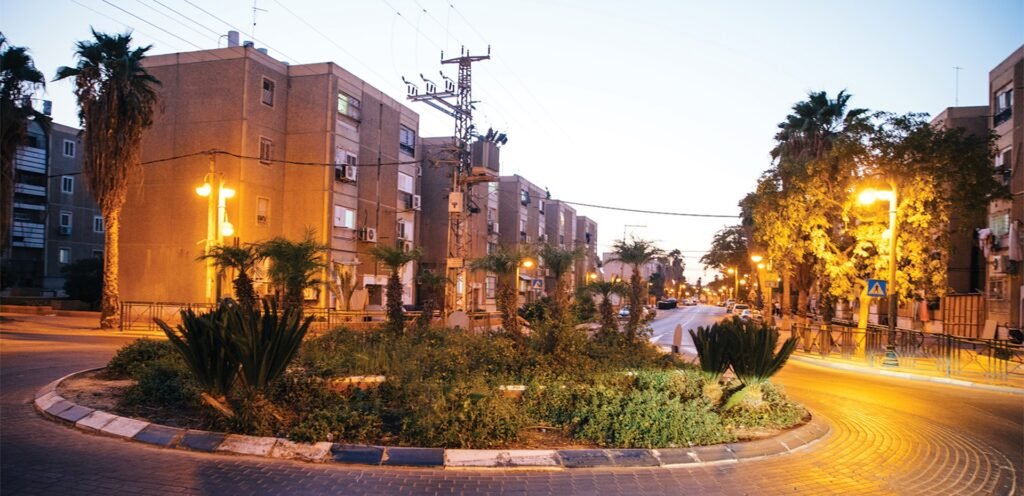 עספיא רחוב עירוני עם כיכר מוארת בלילה באזור מגורים