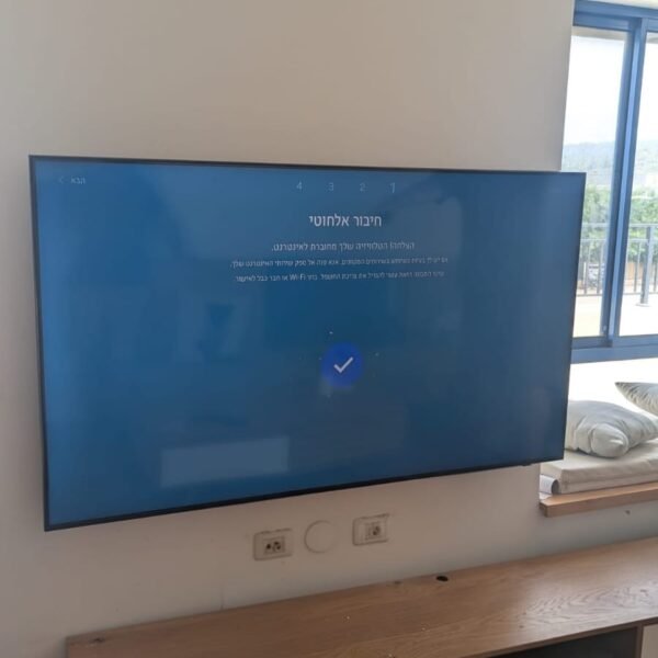 טלוויזיה 65 אינץ' מותקנת על זרוע מפרקית עם קיר בטון בסלון