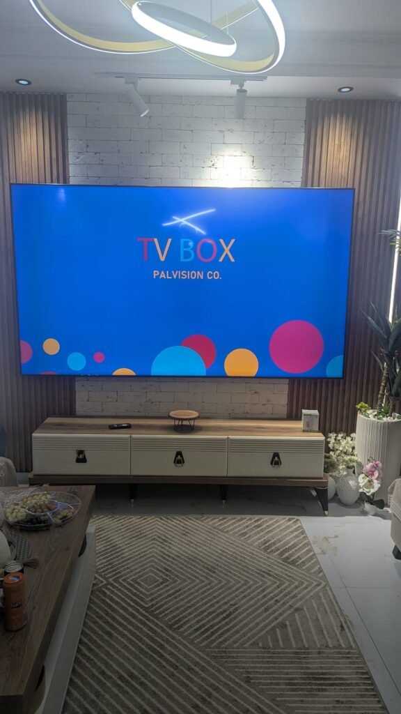 טלוויזיה 100 אינץ' מותקנת על זרוע עם קיר בריקים בסלון בקרית ים