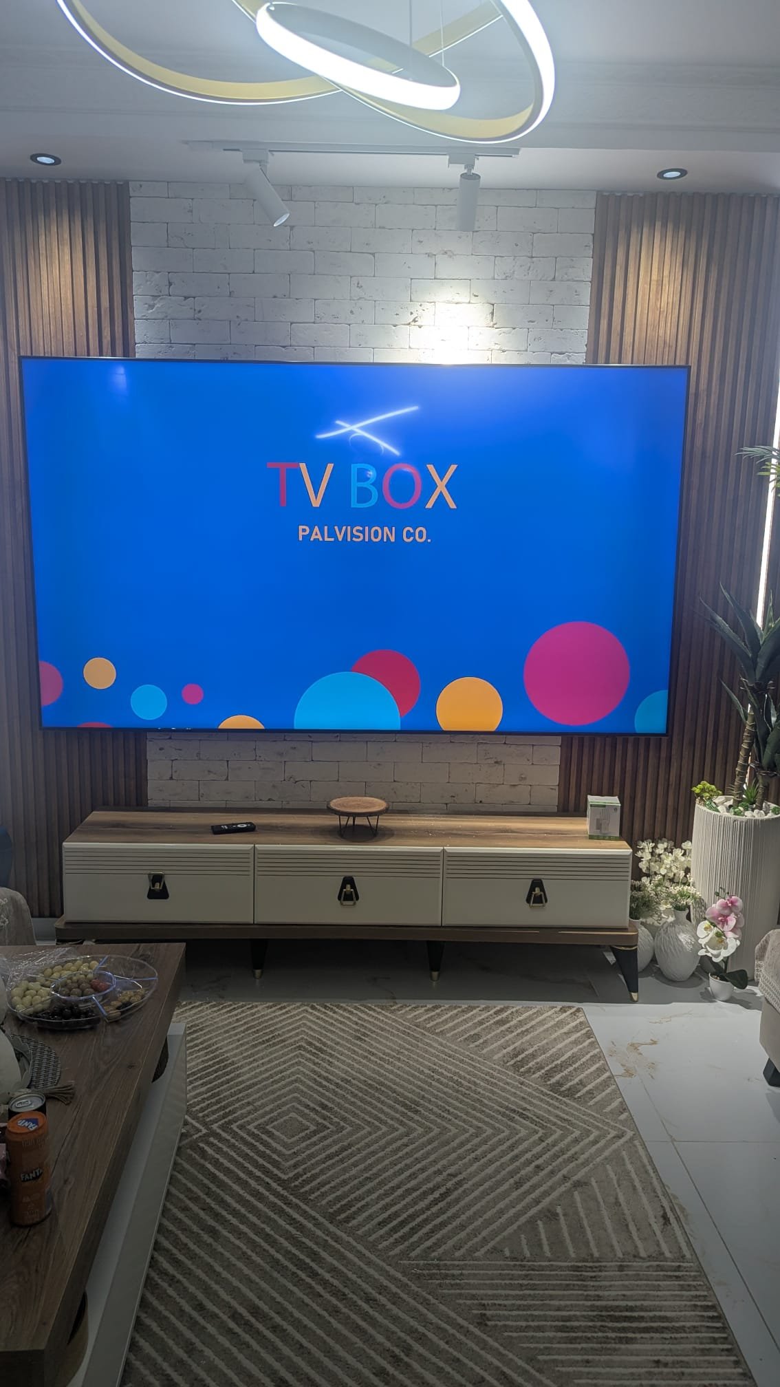 טלוויזיה 100 אינץ' מותקנת על זרוע עם קיר בריקים בסלון בקרית ים