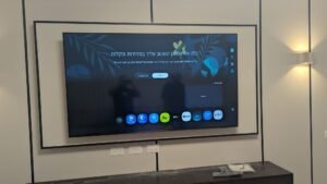 התקנת טלוויזיה 75 אינץ' על נישת קיר עם חיפוי עץ דקורטיבי למראה חם ויוקרתי.