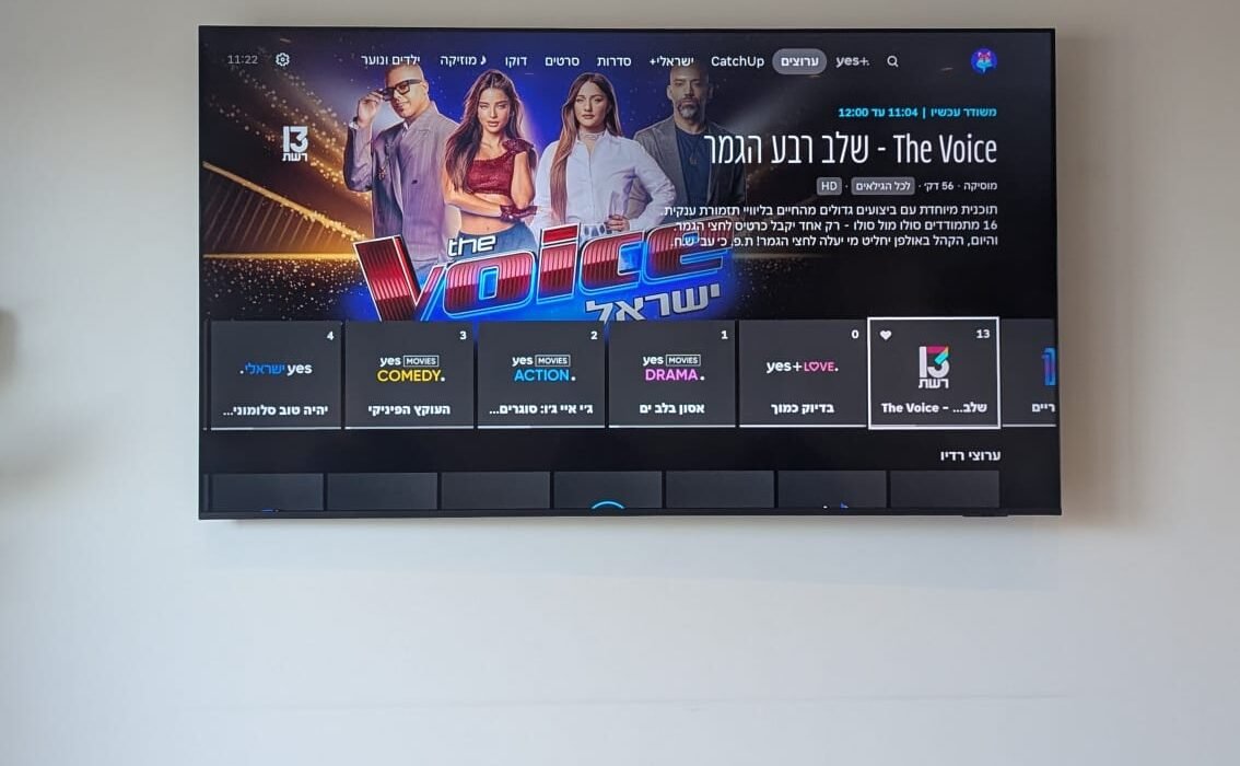 טלוויזיה 85 אינץ מותקנת על זרוע מפרקית עם קיר בטון בסלון בטירת הכרמל